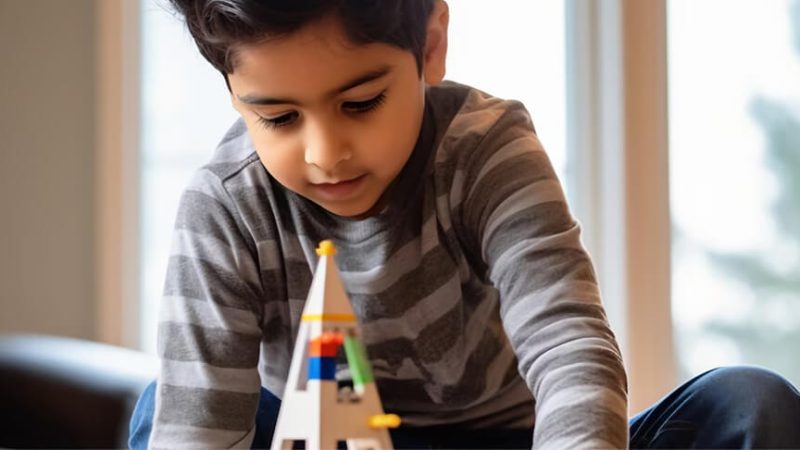 A young child concentrating while building with construction toys
