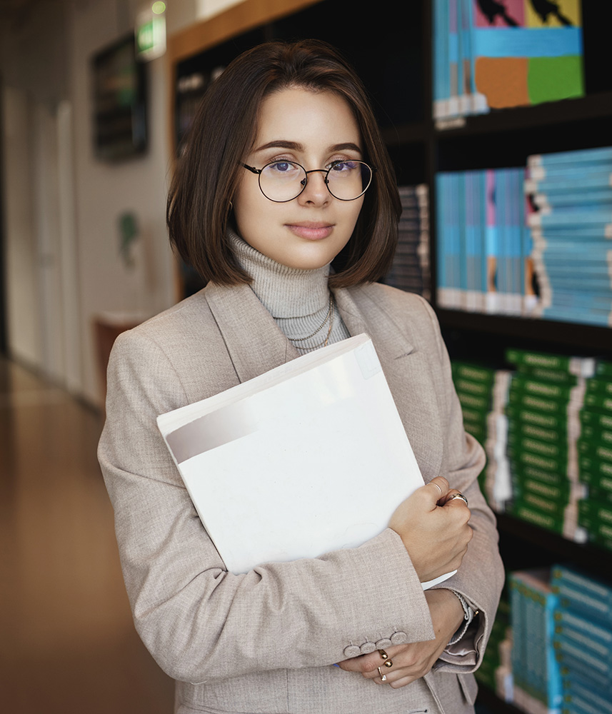 A graduate holding their diploma on graduation day