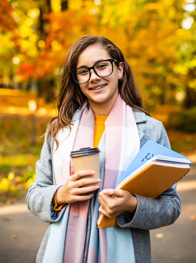 A student crossing campus with a laptop